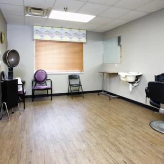 Empty salon room with hairdressing chairs and equipment.