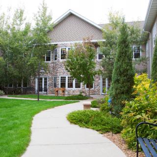 A scenic view of a building surrounded by lush greenery and a winding pathway.
