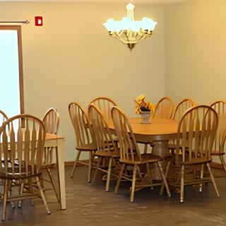 A cozy dining area with wooden furniture and a chandelier.