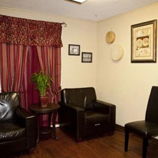 A cozy waiting room with leather chairs and wall decorations.