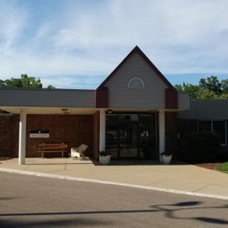 A welcoming entrance to a community building with a clear blue sky.