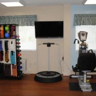A gym room featuring exercise equipment and a TV.