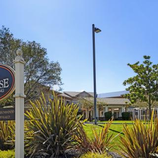 A scenic view of a building with a sign and lush greenery under a clear blue sky.