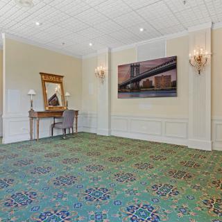 A spacious, elegantly decorated room with a mirror and artwork on the walls.