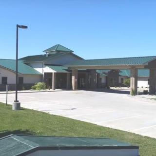 A modern healthcare facility with a green roof and spacious entrance.