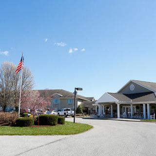 A building with an American flag and a driveway on a clear day.