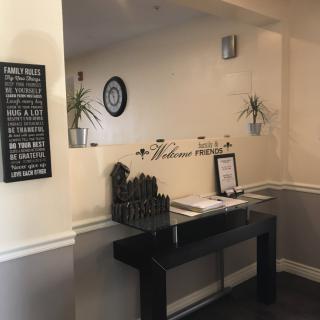 A welcoming reception area with a decorative sign and plants.