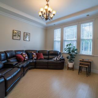 A cozy living room with a sectional sofa and a chandelier.