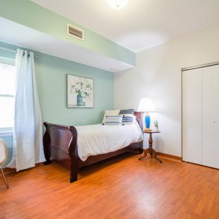 A cozy bedroom with a single bed, wooden floor, and minimalist decor.