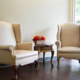A cozy seating arrangement with two armchairs and a small table adorned with flowers.