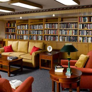 A cozy living room with bookshelves and comfortable seating.