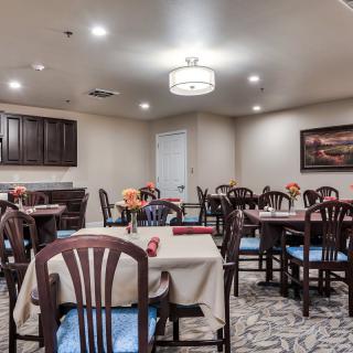 A cozy dining room with neatly arranged tables and chairs, ambient lighting, and elegant decor.