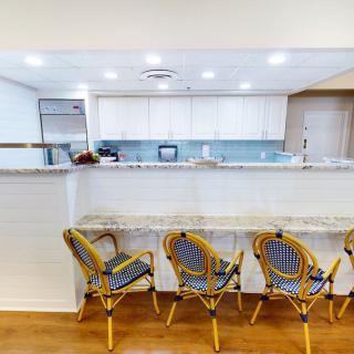 A modern kitchen with a granite countertop and stylish bar stools.