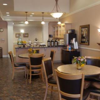 A cozy cafe interior with tables, chairs, and a coffee station.