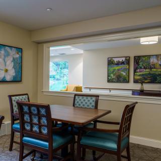 A cozy dining area with a table, chairs, and artwork on the walls.