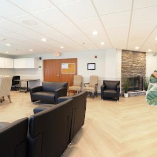 A modern lounge area featuring comfortable seating and a cozy fireplace.