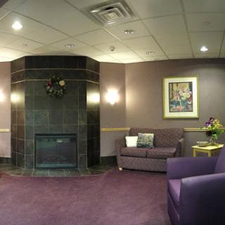 A cozy lobby area featuring a stylish purple color scheme and a welcoming fireplace.