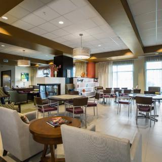 A spacious and well-lit seating area with modern furniture and large windows.