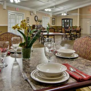 Elegantly set dining room with neatly arranged tables and floral decoration.