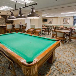 A well-furnished game room featuring a pool table and seating area.