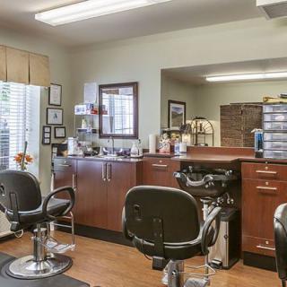 Interior view of a cozy barber shop with chairs and mirrors.