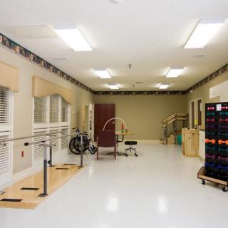 A rehabilitation room equipped with parallel bars and exercise equipment.
