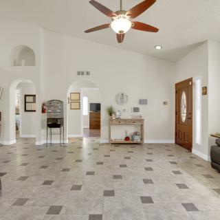 A spacious living room with tile flooring, a ceiling fan, and decorative elements.