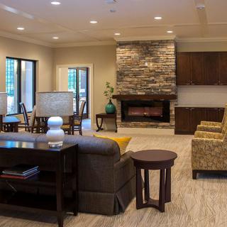 A cozy living room with modern decor and a stone fireplace.