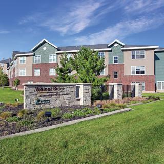 A modern multifamily apartment building surrounded by well-maintained landscaping.