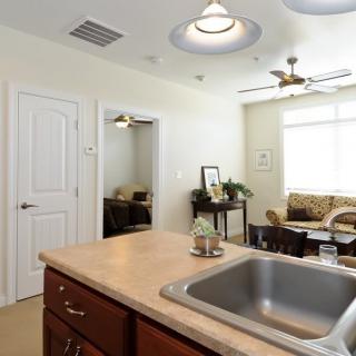 An open kitchen and living room area with modern furnishings and bright lighting.