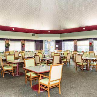 An empty restaurant dining area with neatly arranged tables and chairs.