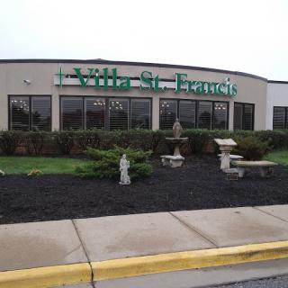 Exterior view of the St. Francis healthcare facility, featuring landscaped areas and signage.