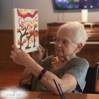 An elderly woman enjoys a colorful book, reflecting moments of joy and engagement.