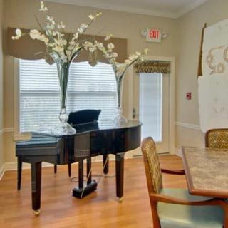 A beautifully decorated living room featuring a grand piano adorned with flowers.