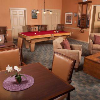 A cozy game room with a pool table and comfortable seating.