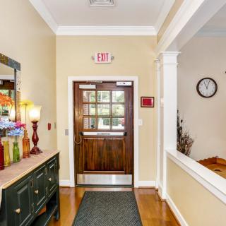A well-decorated entrance hall with a wooden door and a wall clock.