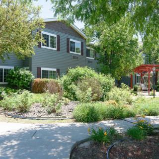 A suburban house with a beautifully landscaped garden and driveway.
