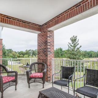 A cozy outdoor seating area on the balcony, perfect for enjoying a serene view.