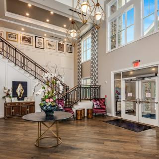 A spacious and elegantly designed lobby with a grand staircase and modern decor.