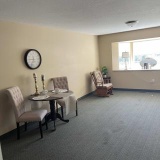 A cozy living area with chairs, a small table, and a large window.