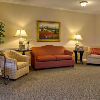 A cozy living room setup with sofas, armchairs, and warm lighting.