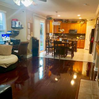 An open concept living area featuring a cozy living room, dining space, and kitchen with warm wooden accents.