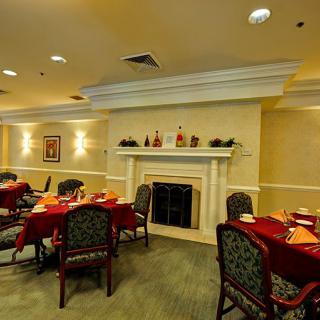 A cozy dining room with elegantly set tables and a fireplace.