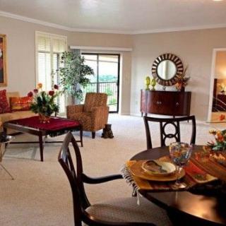 A stylishly decorated living room with a dining area, featuring elegant furniture and decorative elements.
