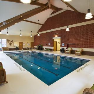 An inviting indoor swimming pool with comfortable seating and warm lighting.