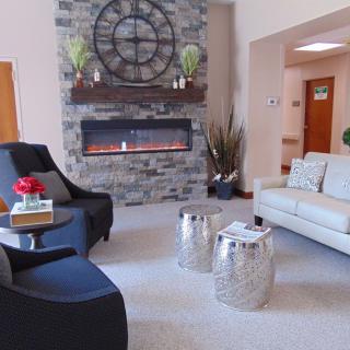 A modern living room with a stone fireplace, cozy seating, and stylish decor.