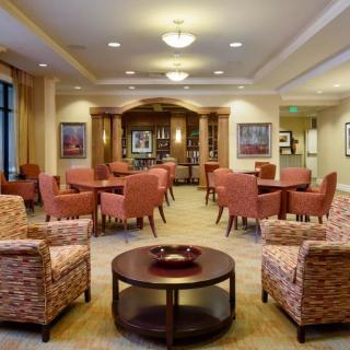 A well-furnished lounge area with comfortable chairs and tables, suitable for relaxation or meetings.