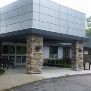A modern building entrance featuring stone columns and a paved pathway.