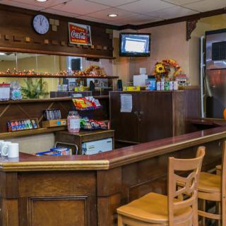 A cozy bar area with a counter and seating, featuring snacks and beverages on display.
