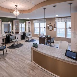 A modern salon interior with styling stations and a reception area.